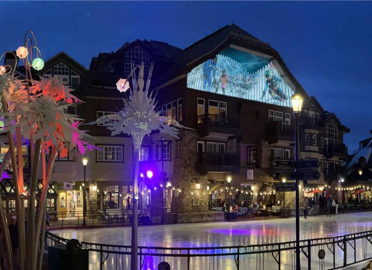 A photograph of the clock tower at the Beaver Creek Resort with media projected on it from the Bezark Company